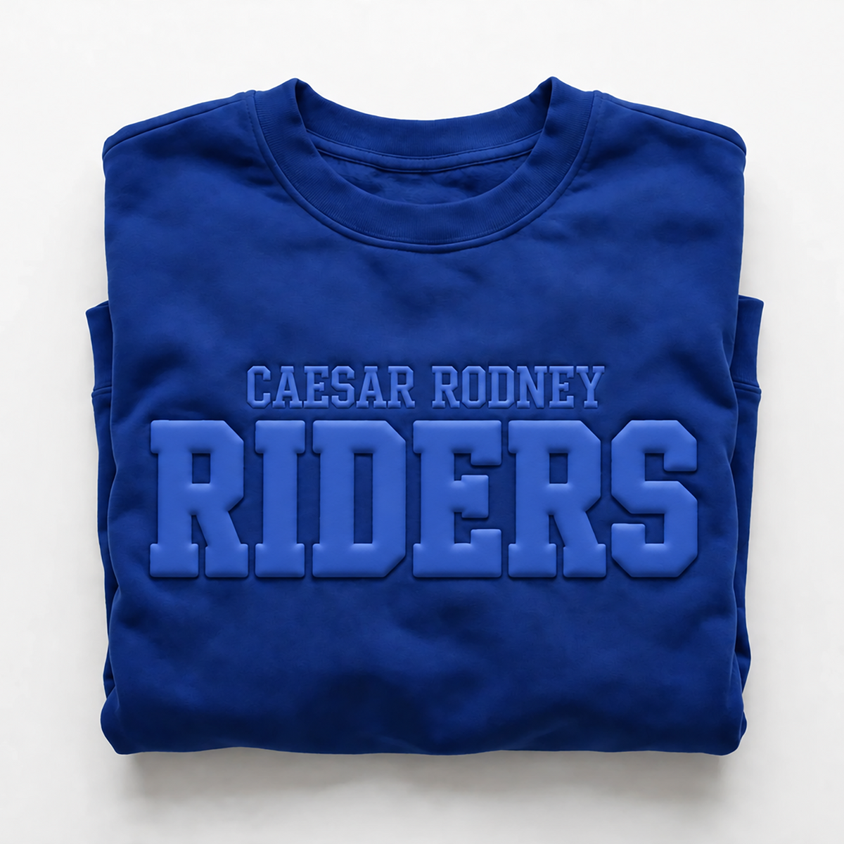 A folded royal blue crewneck sweatshirt featuring 'CAESAR RODNEY RIDERS' printed in matching blue varsity-style lettering on the front, set against a clean white background.
